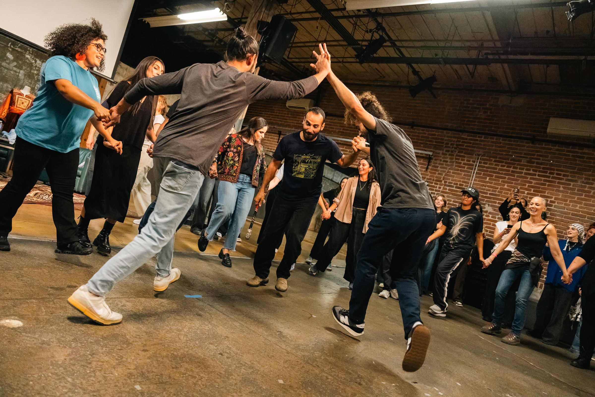 Dynamic action shot of dancers holding hands and jumping