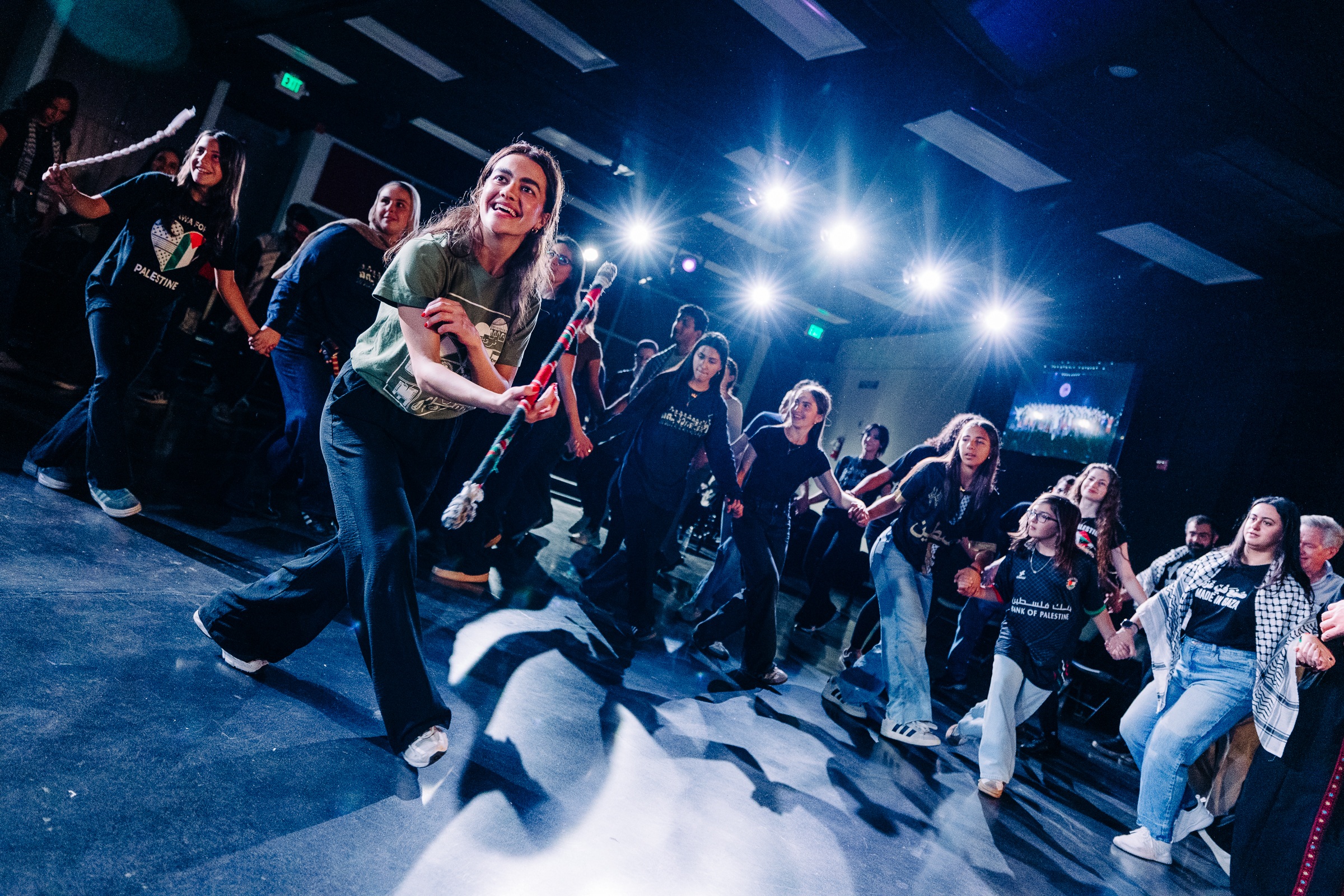 Large community gathering in dabke circle with diverse participants