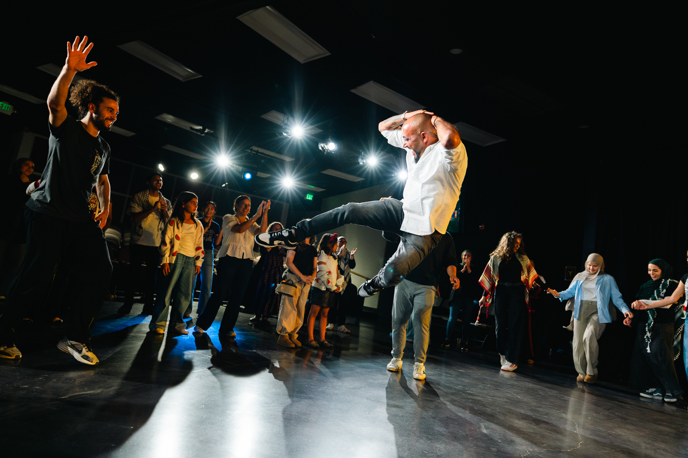 Dancer mid-leap with dramatic stage lighting
