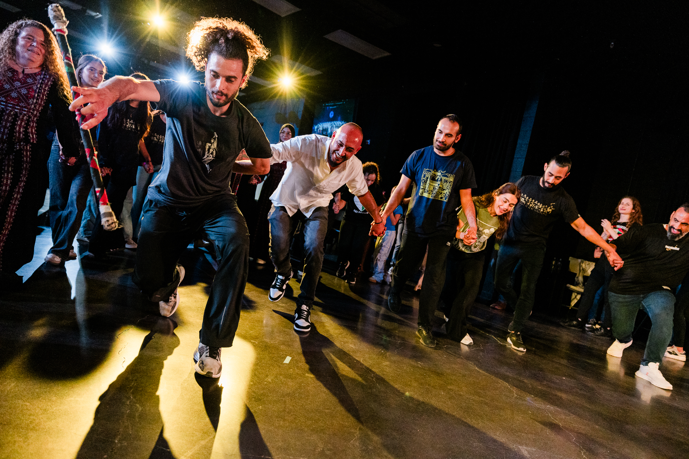 Energetic dabke line formation with dramatic lighting
